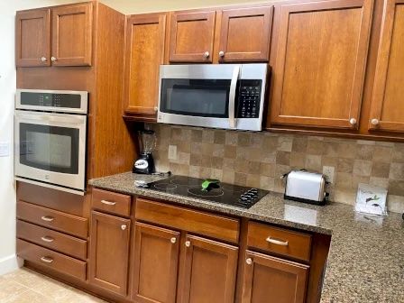 image Kitchen with rich wood cabinetry, full-sized appliances, and counter space for meal prep