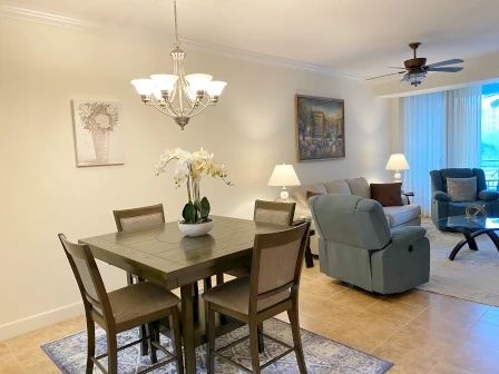 image Dining table beneath a floral pendant light — open to the kitchen and living area