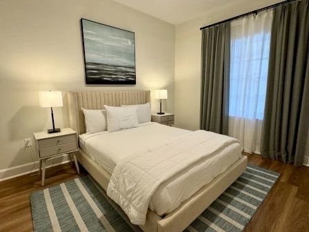 image Queen bedroom with soft neutral tones, plush white bedding, and a window for natural light
