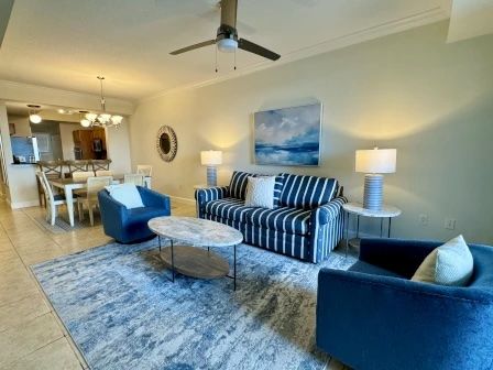 image Living area with ocean-toned sofa, coastal artwork, and warm lamp lighting throughout