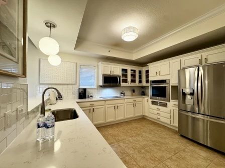 image Bright kitchen with white cabinetry, full-sized stainless appliances, and a clean open layout