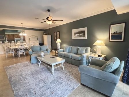 image Living area with a plush sofa, warm lighting, and easy access to the kitchen and balcony