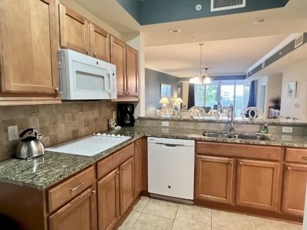 image Kitchen with rich wood cabinetry, granite counters, and full-sized stainless appliances