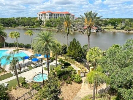 image View from the balcony taking in the community pool, lush greenery, and open Intracoastal beyond