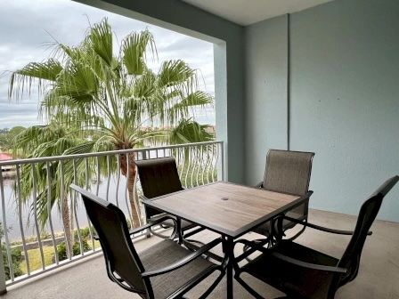 image Balcony table and chairs with palms on either side — golden-hour views over the Intracoastal