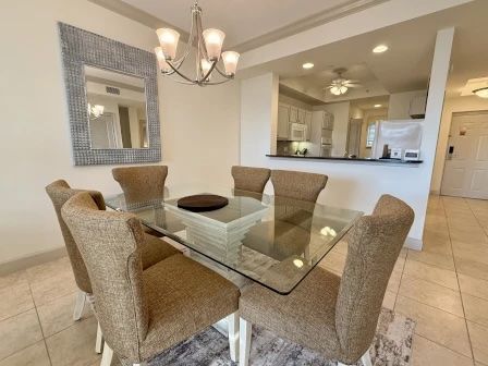 image Glass dining table with seating for the group beneath warm overhead lighting