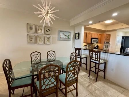image Dining area beneath a warm overhead fixture — open to the kitchen and balcony