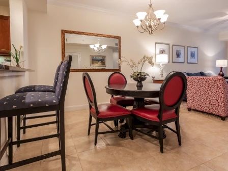 image Round dining table with bold red chairs — a lively and bright spot for group meals