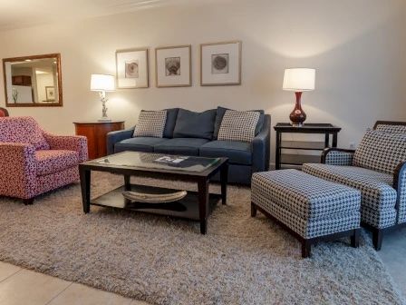 image Living area with soft-toned furnishings, warm lighting, and open flow to the kitchen
