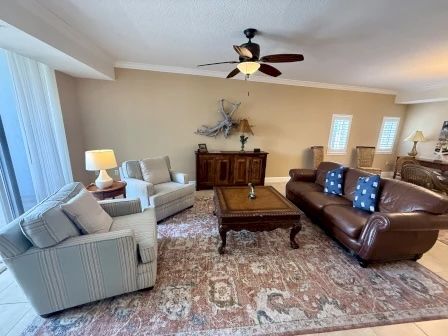 image Living area with warm brown and blue tones, comfortable seating, and natural light from the balcony