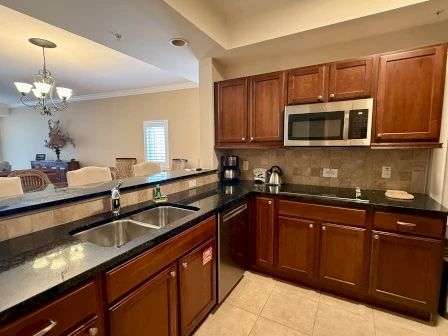 image Kitchen with dark cabinetry, granite counters, and full-sized stainless appliances