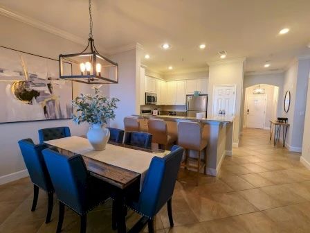 image Dining table for six with soft overhead lighting — open to the kitchen and living area