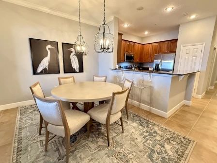 image Round dining table with six seats beneath a statement pendant light fixture