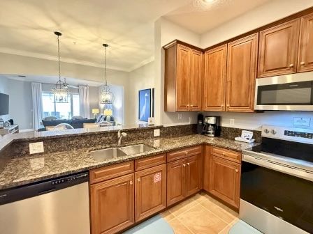 image Kitchen with rich wood cabinetry, granite counters, and full-sized stainless appliances