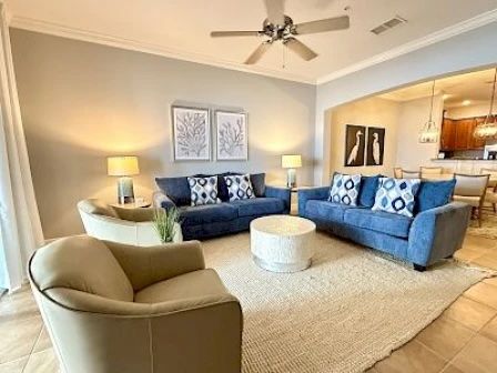image Living area with soft blue sofas, natural light through large windows, and views to the balcony