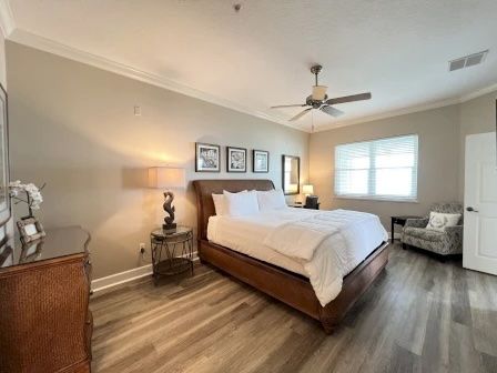 image King master bedroom with wooden bed frame, white linens, and natural light from the window