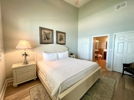 image King master bedroom with white linens, warm tones, and a direct path to the ensuite bathroom