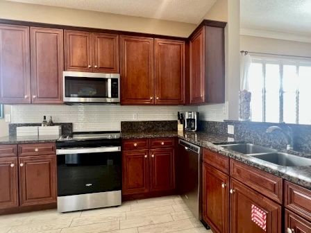 image Kitchen with granite counters, stainless steel appliances, and room for the whole group to cook