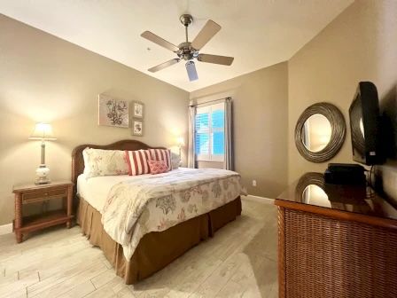 image King bedroom with warm tones, white linens, and natural light from the window