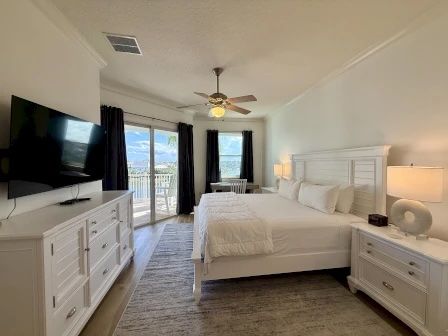 image King master bedroom with white linens, lake views, and direct access to the private balcony