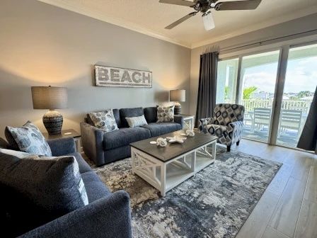 image Living room with soft blue tones, coastal wall decor, and a flat-screen TV for group downtime