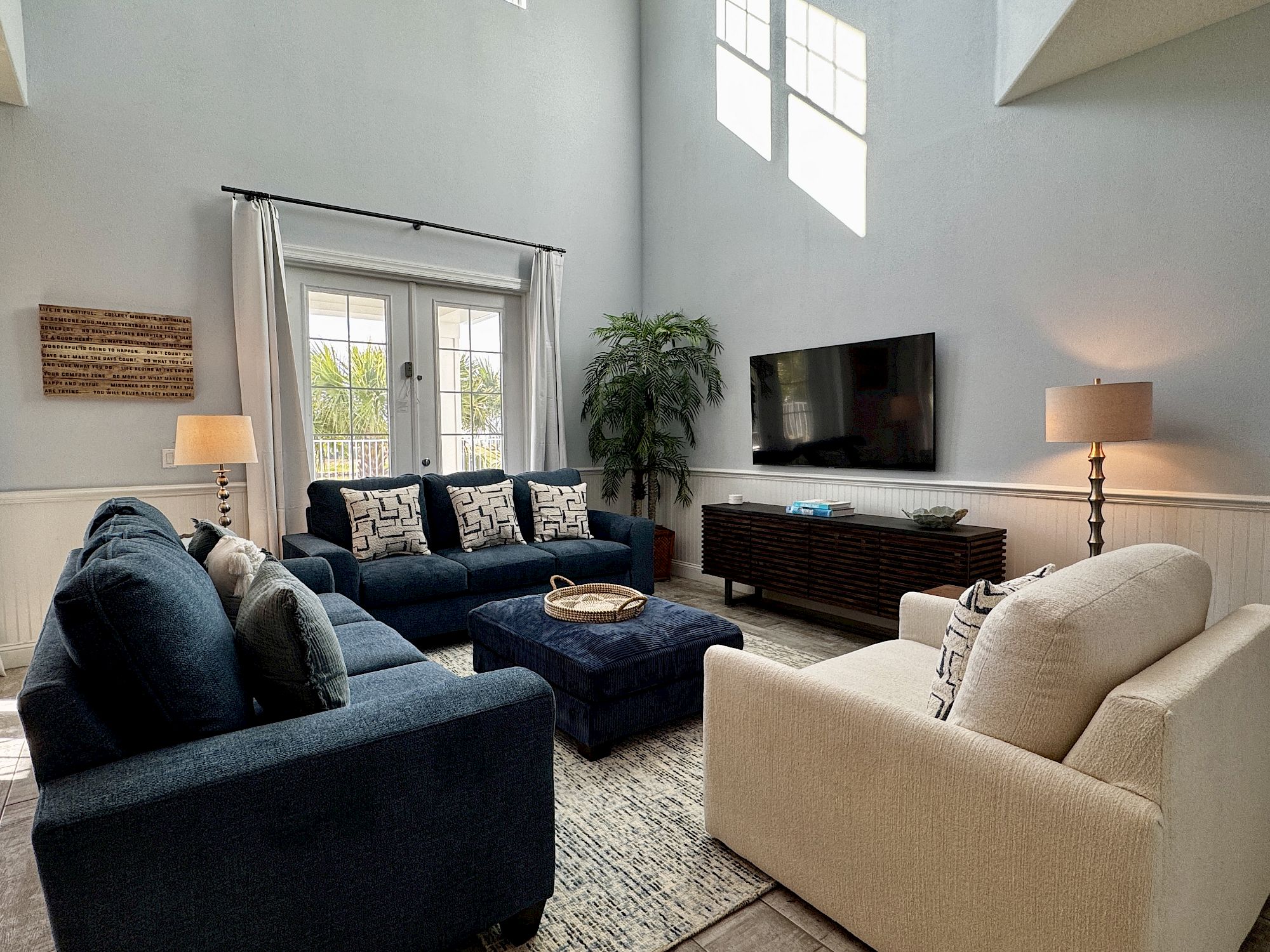 image Bright main living area with plush sofas and natural light — the waterfront views outside set the tone for the day