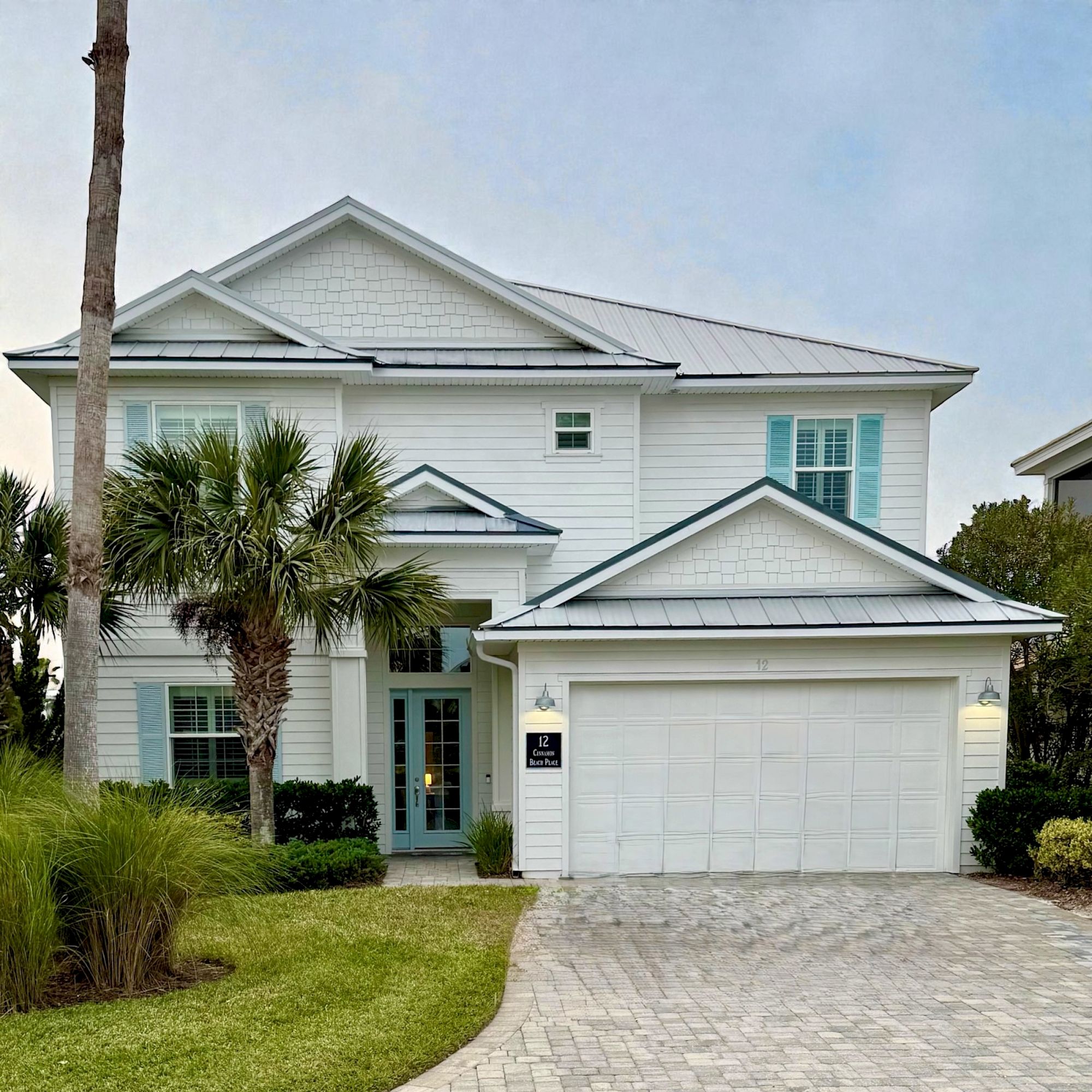 image Multi-story exterior with covered lanai, lush landscaping, and direct access to the waterfront pool