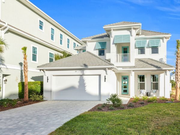 image Exterior view of the home with waterfront access and manicured landscaping