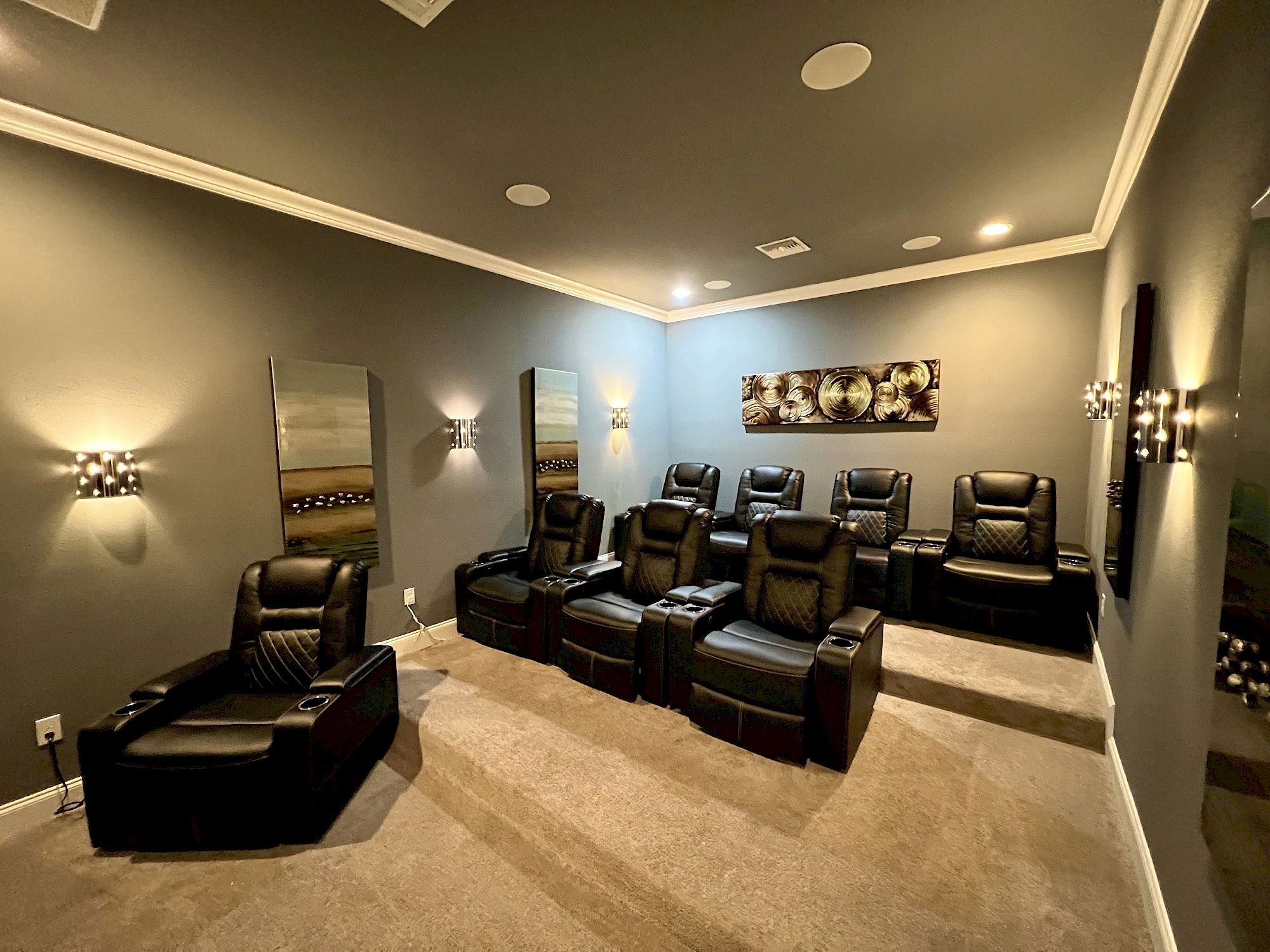 image Private theater room with tiered seating, ambient lighting, and a large screen
