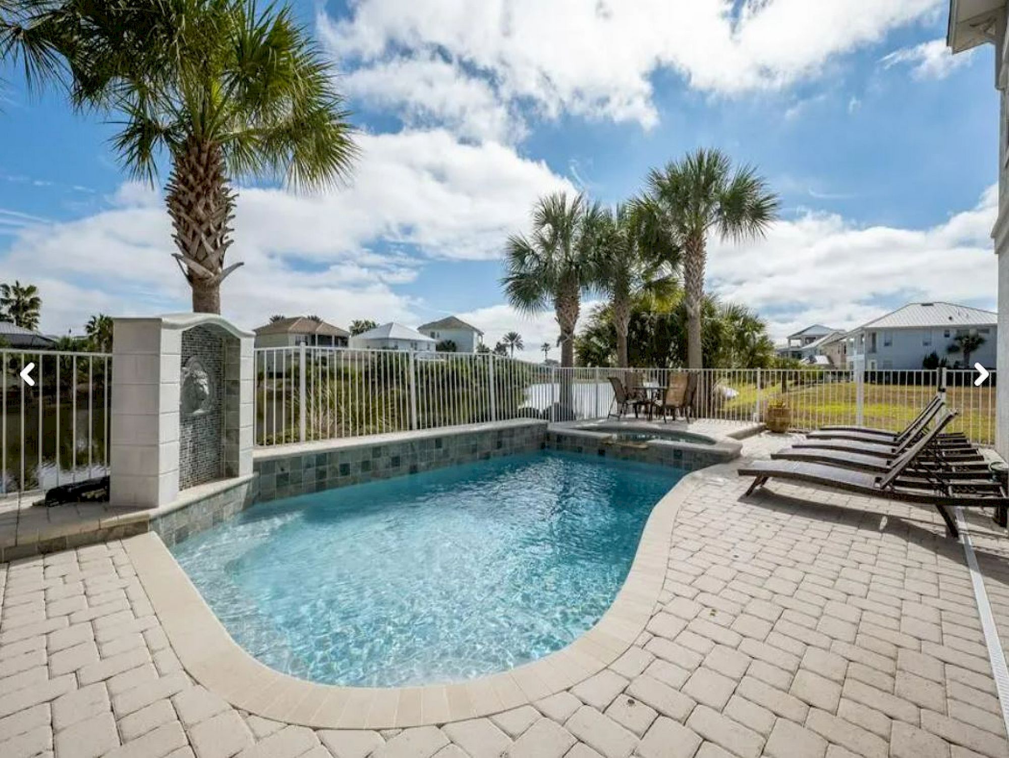 image Private pool with spa and surrounding palms — the patio and summer kitchen sit just behind