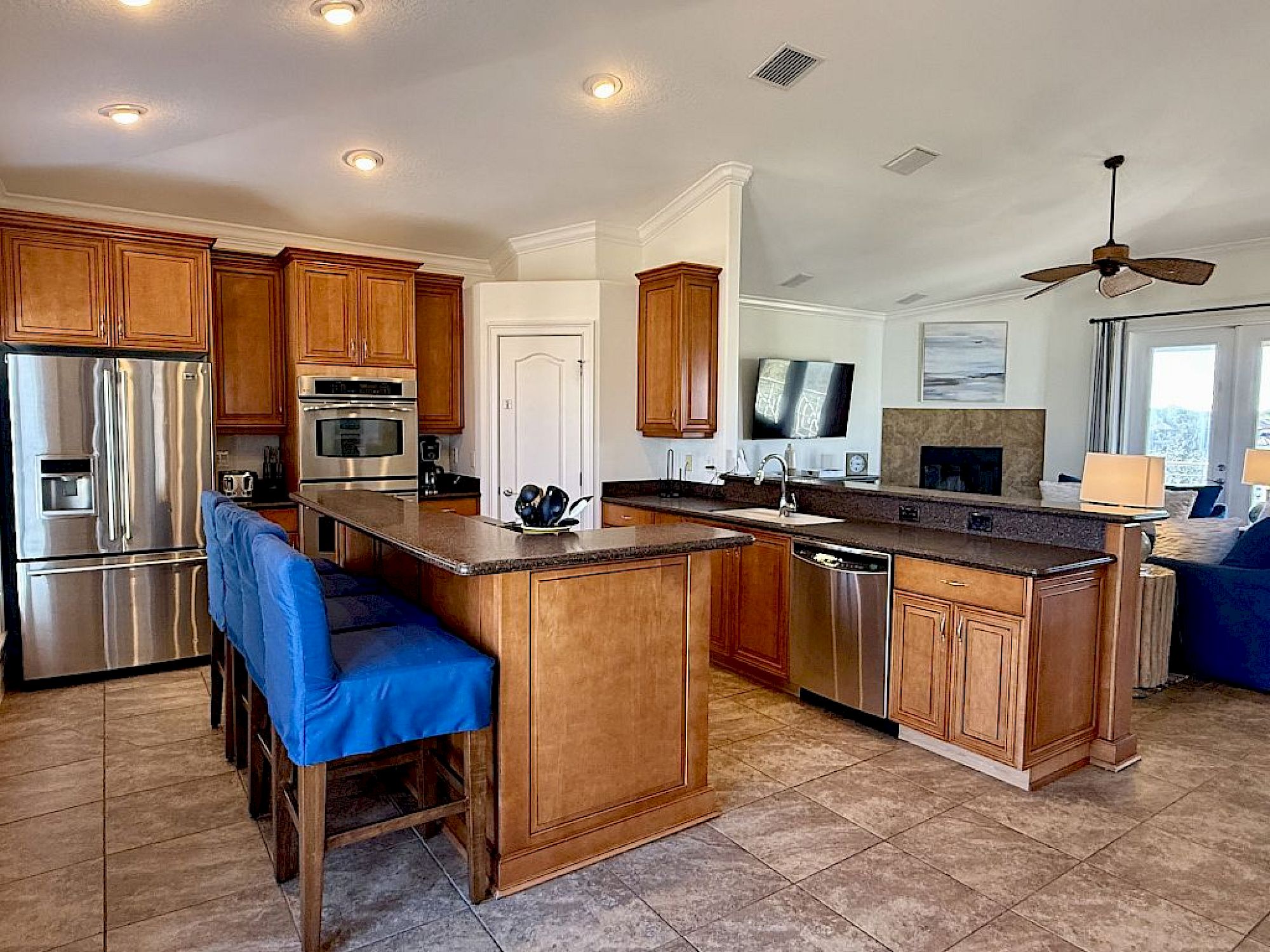 image Kitchen with granite island, bar seating, and full-sized stainless appliances throughout