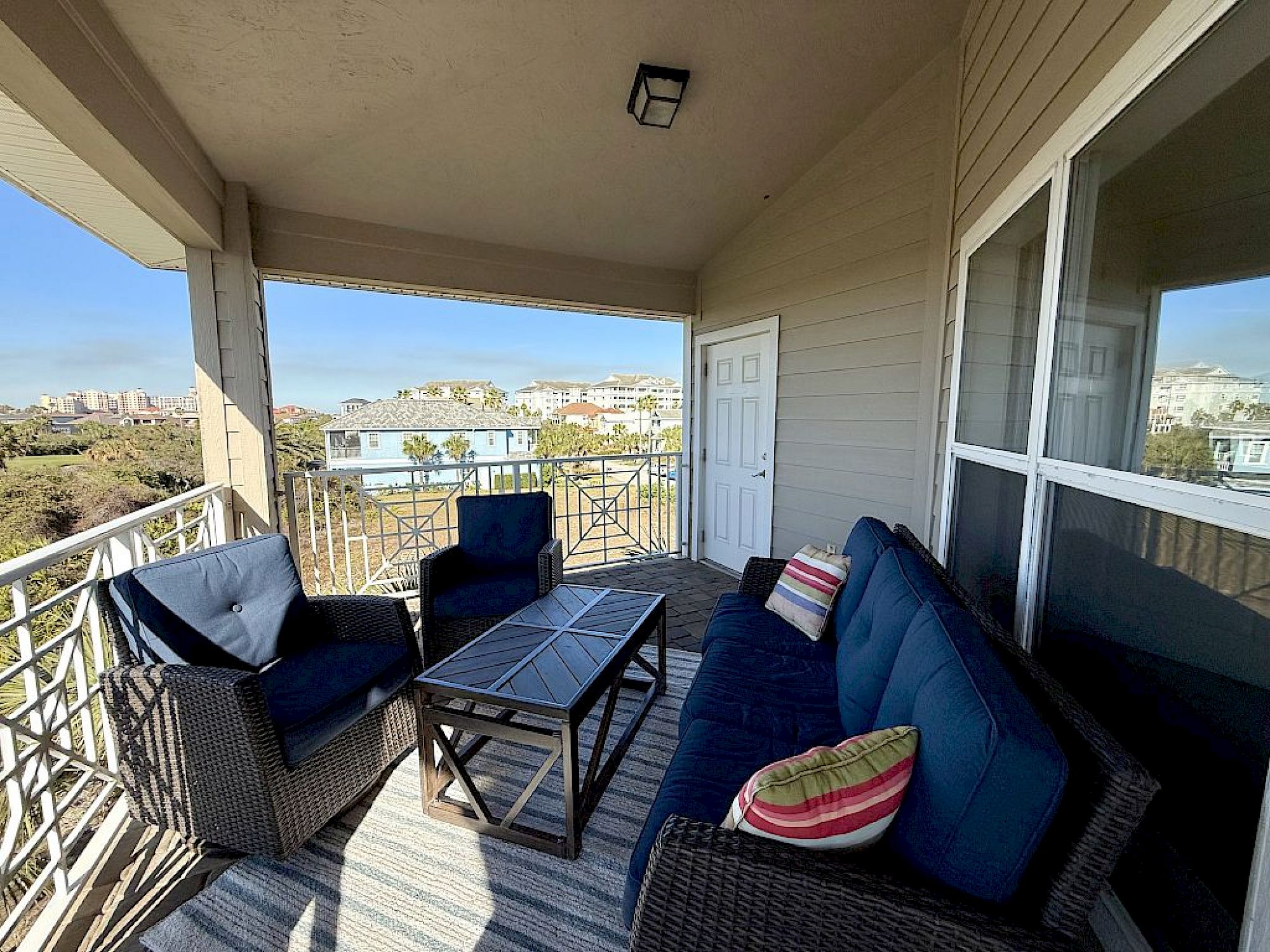 image Sunlit balcony with two chairs and a table overlooking the golf course and surrounding greenery