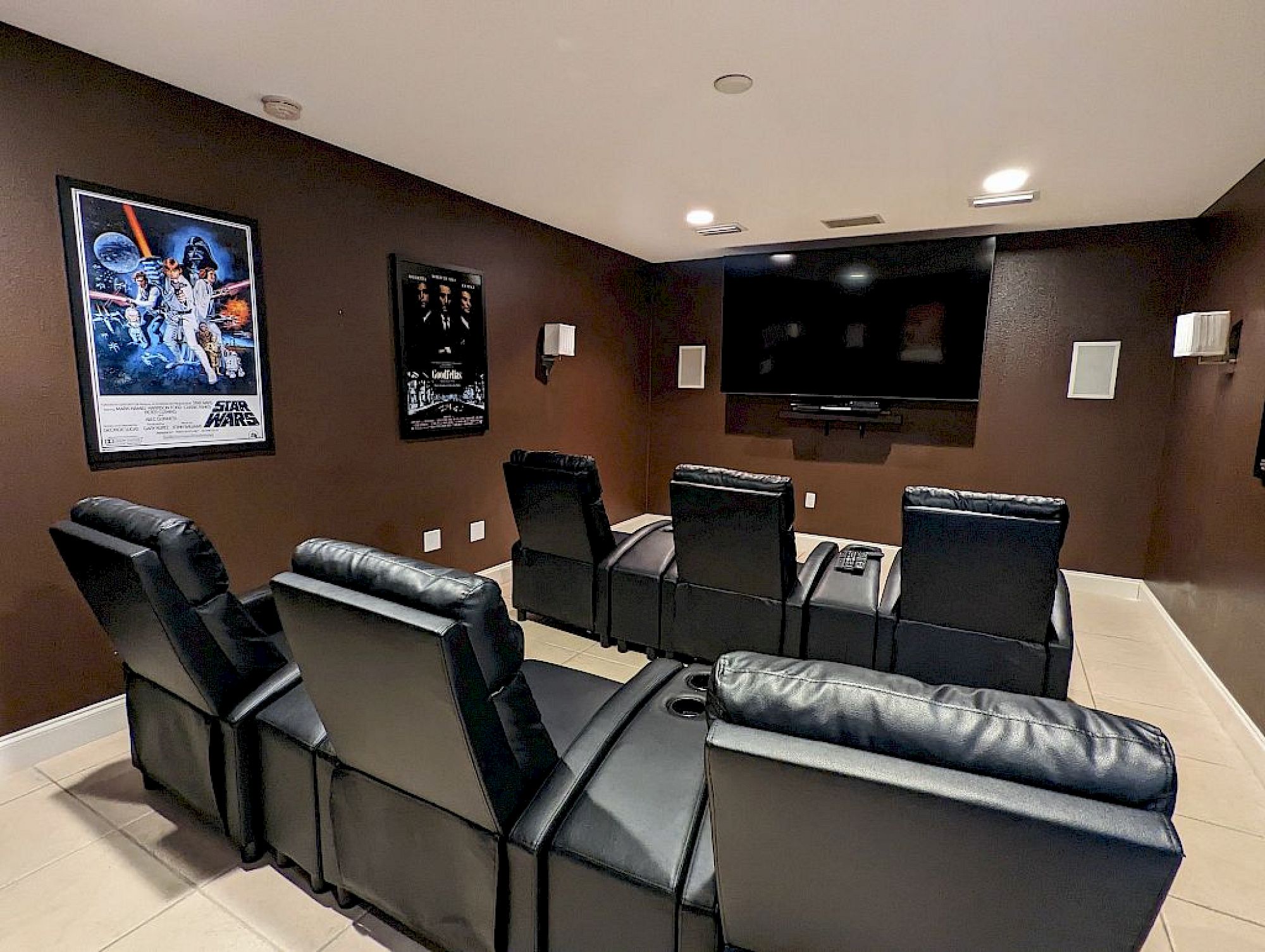 image Dedicated theater room with tiered recliner seating and film posters — movie night is sorted