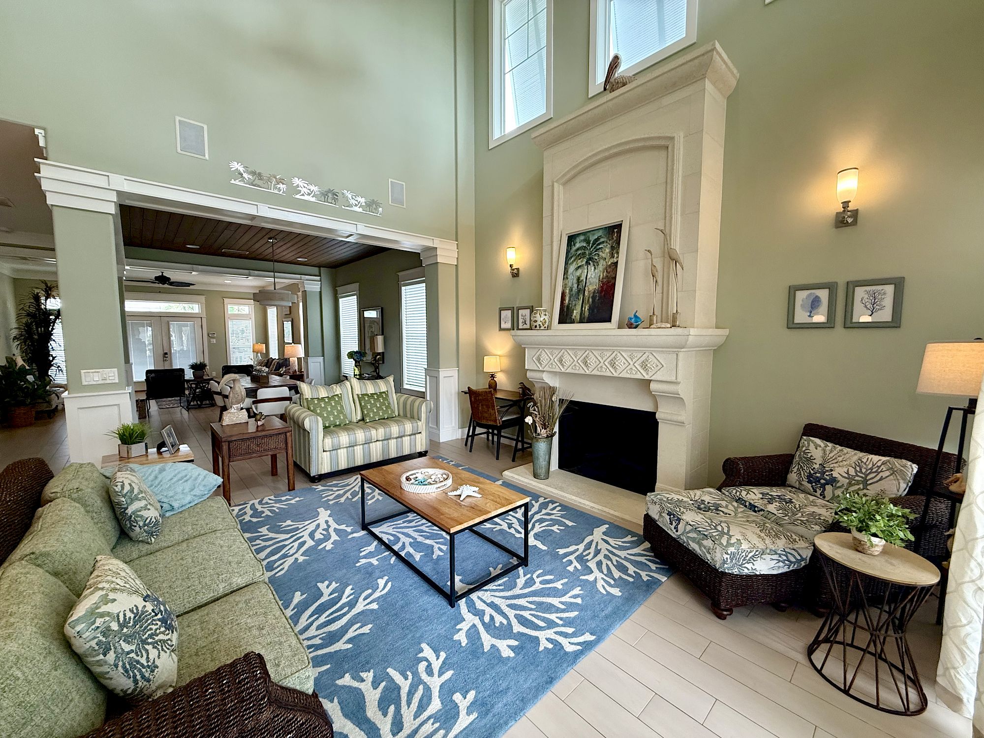 image Living area with electric fireplace, high ceilings, plush sofas, and natural light from tall windows