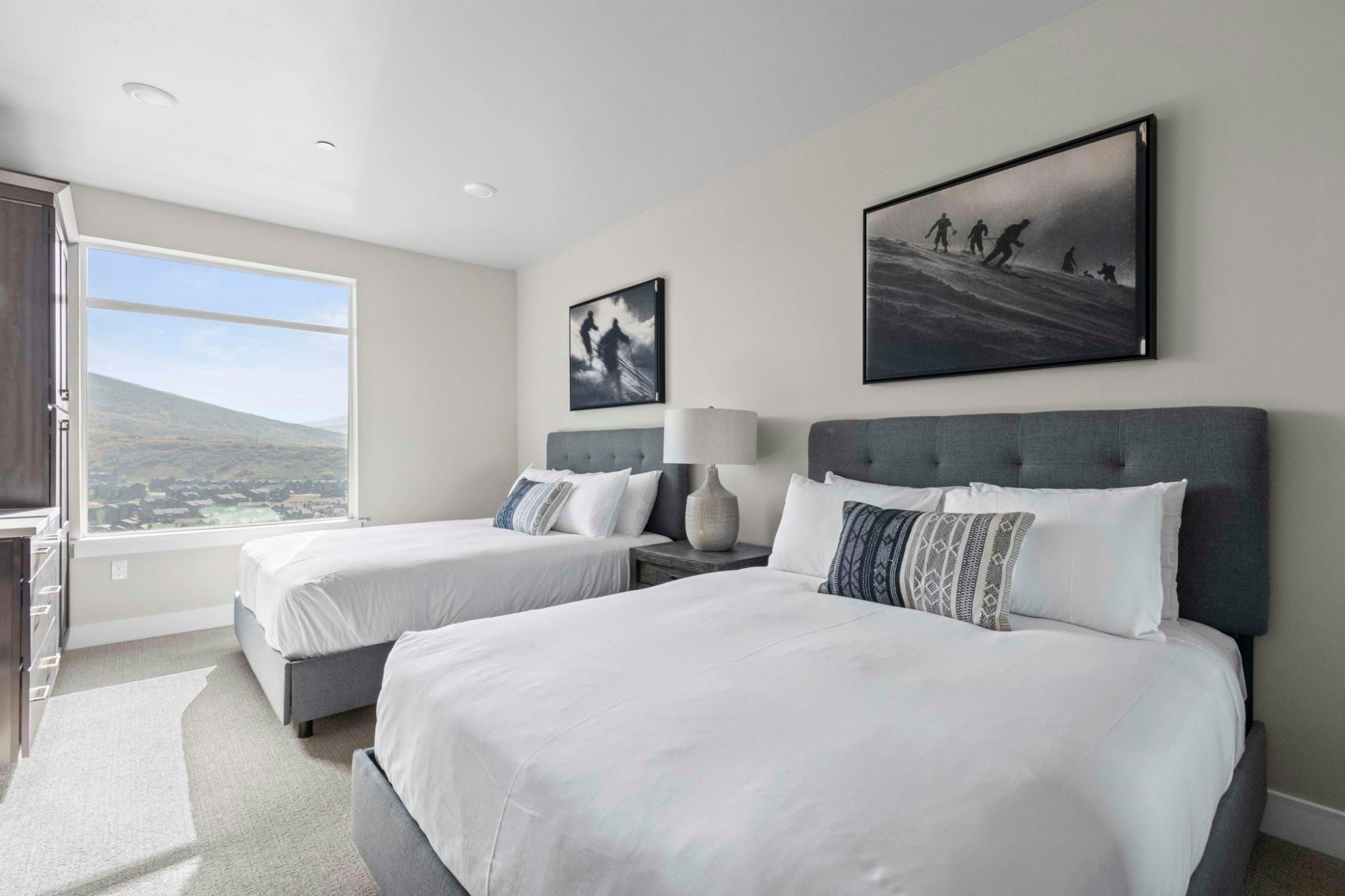 image Two-queen bedroom with tufted grey headboards and large mountain view window