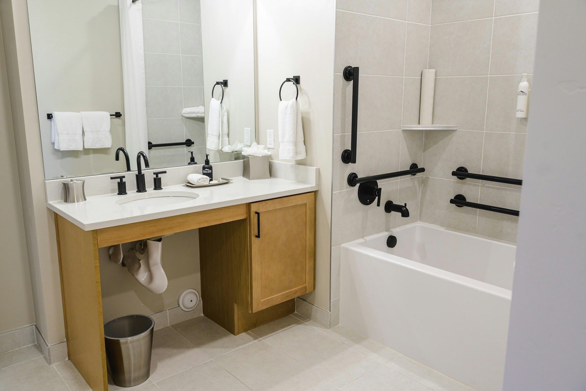 image Accessible bathroom with grab bars on the tub surround and knee-clearance vanity