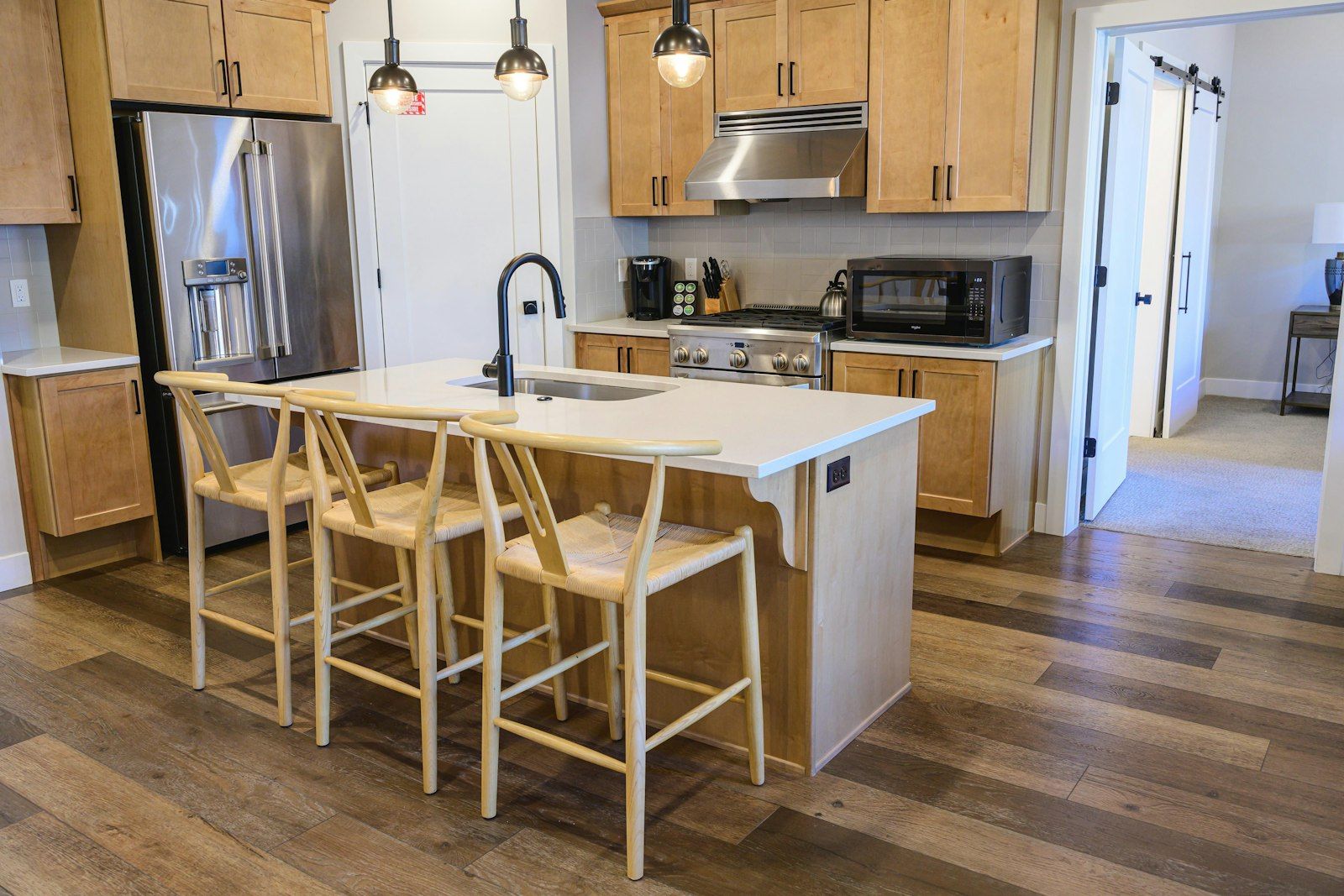 image Fully equipped kitchen with center island seating, gas range, and stainless steel refrigerator