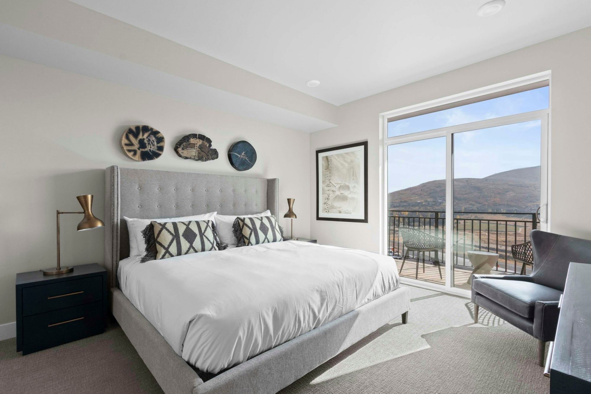 image King bedroom with plush headboard, mountain views, and balcony access