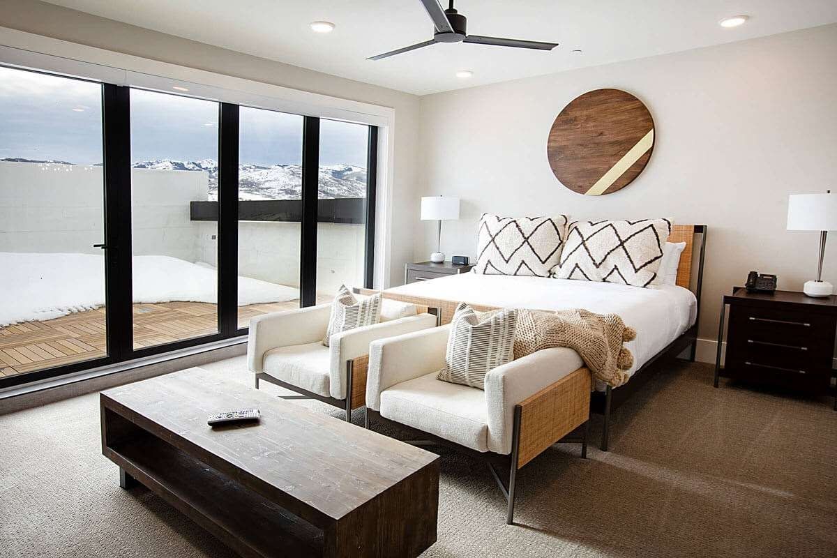 image King bedroom with panoramic mountain and ski area views through floor-to-ceiling glass