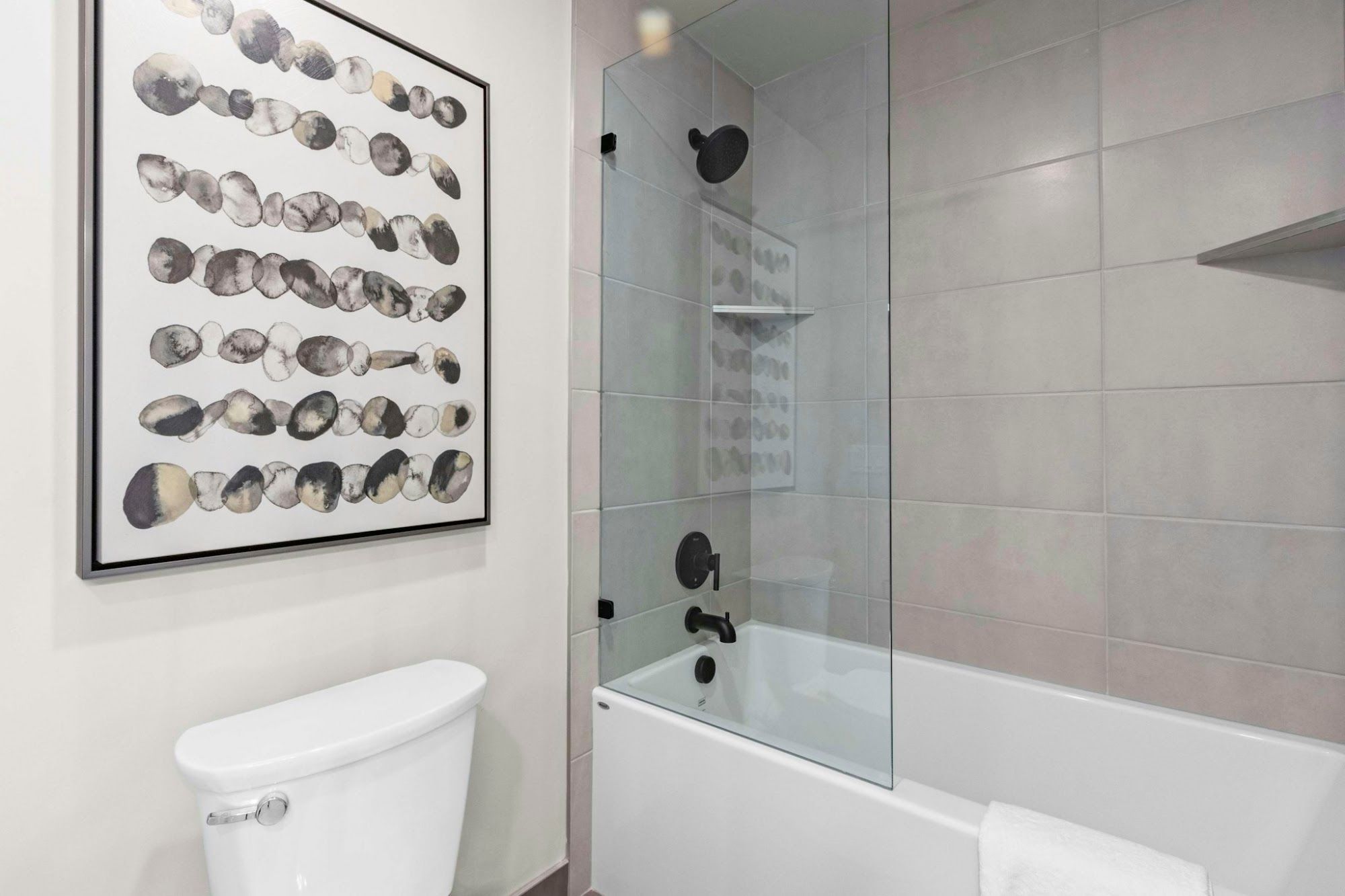image Bathroom with soaking tub and glass-enclosed shower, matte black fixtures, and decorative wall art