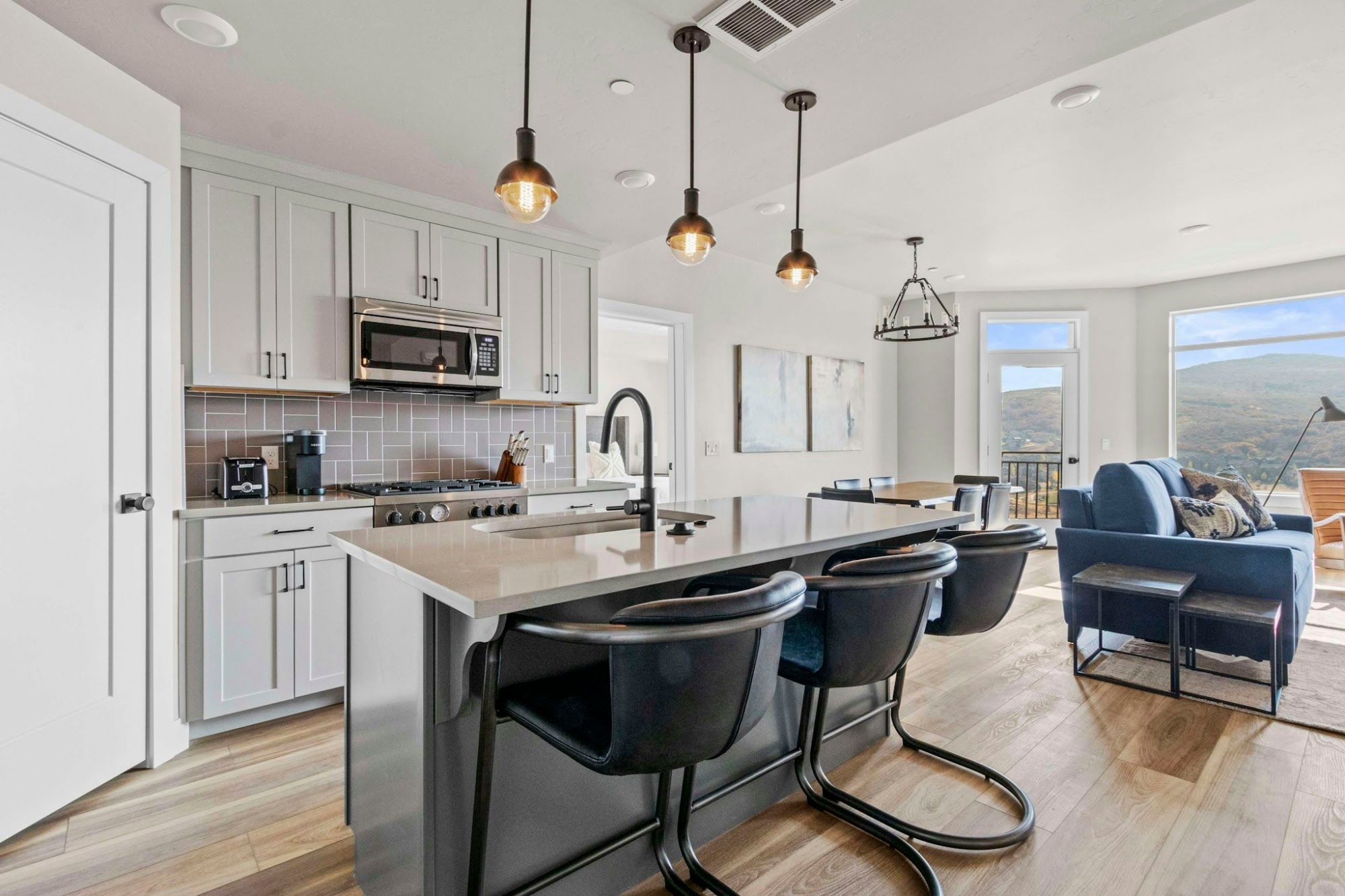 image Fully equipped kitchen with island seating, gas range, and open flow to living area