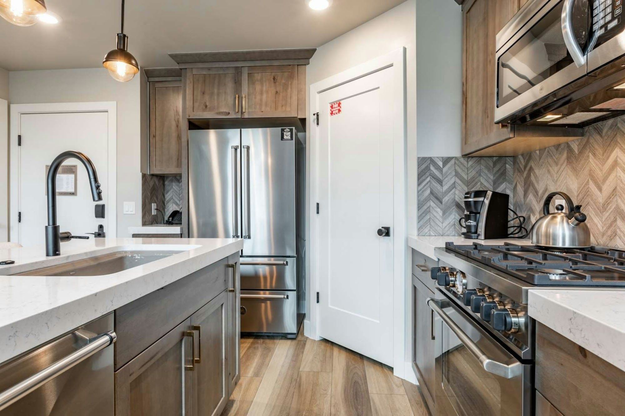 image Fully equipped kitchen with stainless appliances and refrigerator