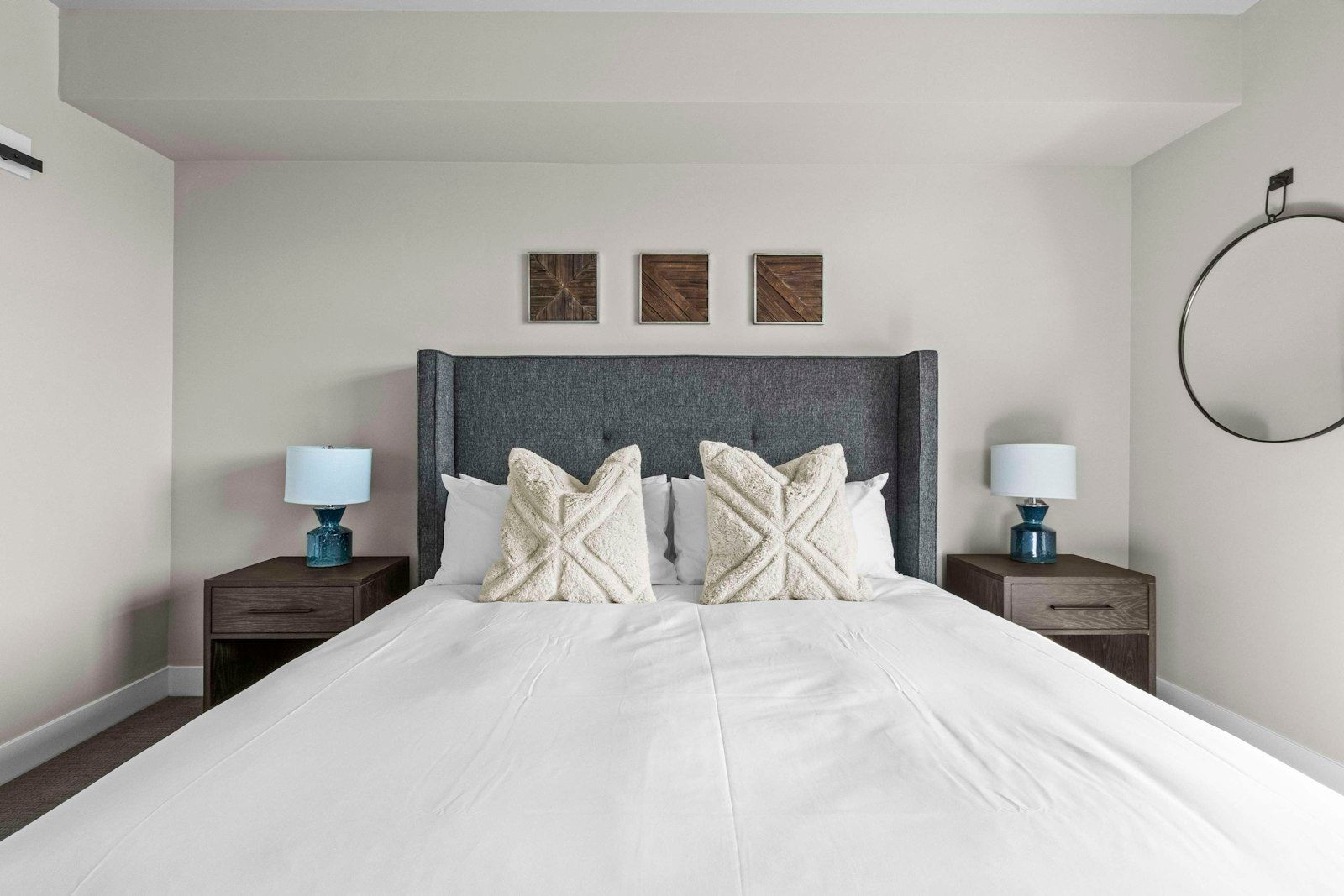 image King bedroom with dark upholstered headboard, white bedding, and two nightstands