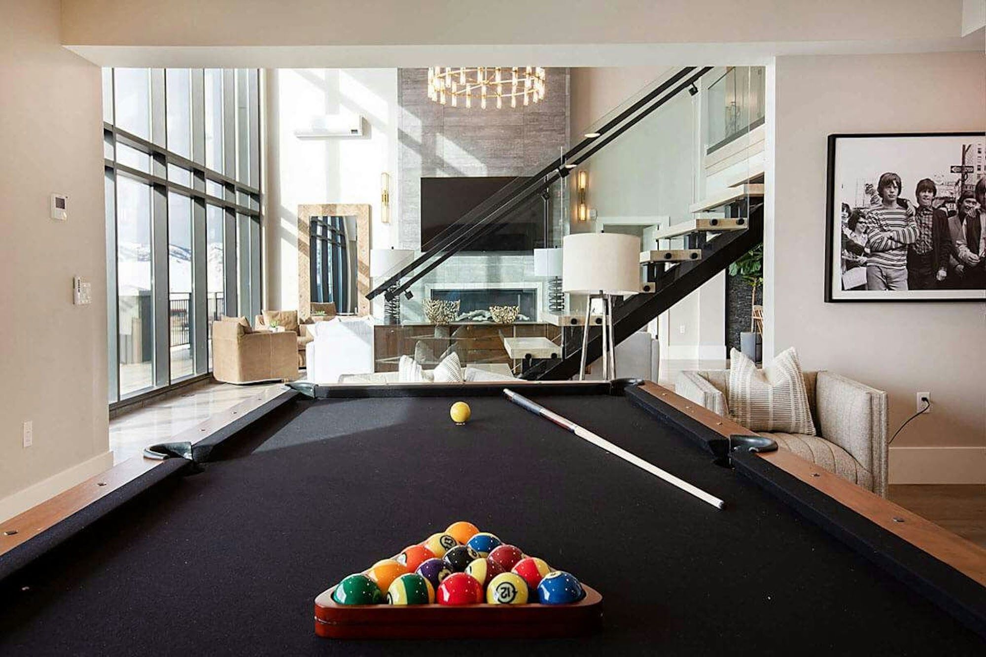 image Upper-level pool table lounge overlooking two-story living room