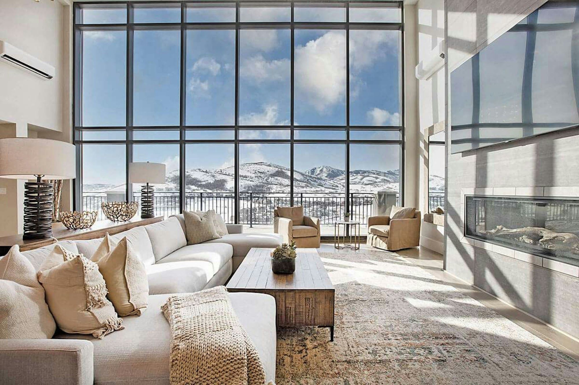 image Spacious living area with large windows and mountain views