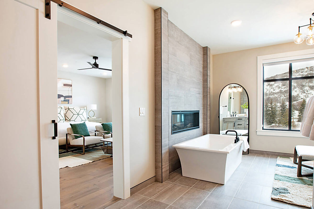 image Bathroom with a freestanding tub, a wall-mounted fireplace, and a window with a mountain view