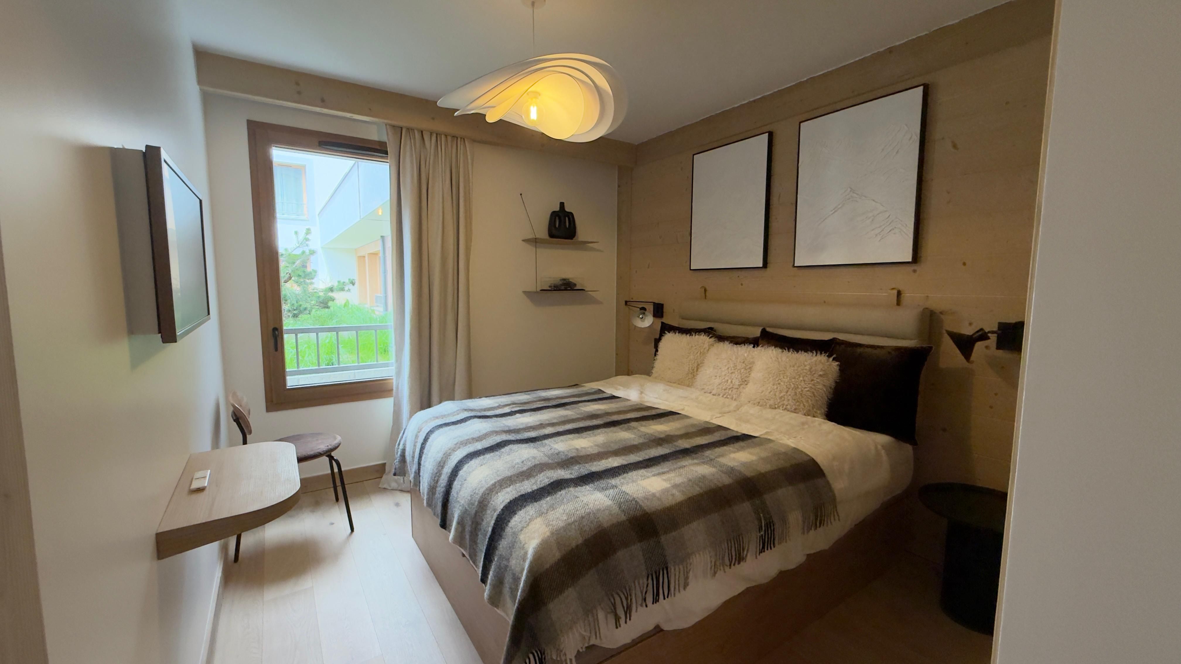 image Floor heating keeps this double bedroom snug after days on the slopes, with a wall-mounted TV for evenings in