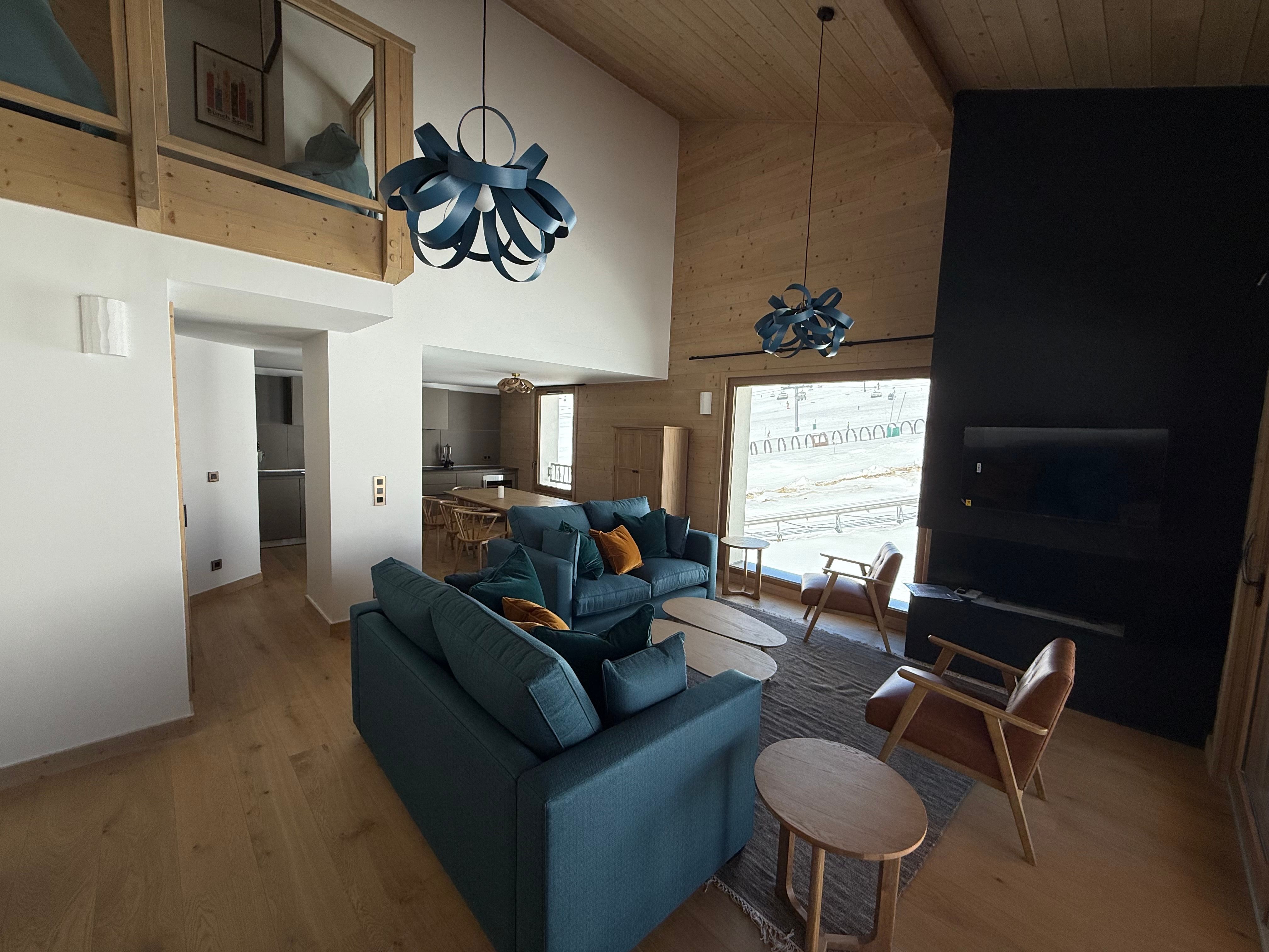 image Floor-to-ceiling windows fill this bright living area with mountain views, while the mezzanine adds a wonderful sense of space above.