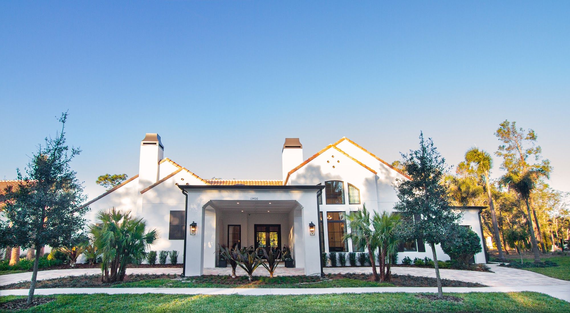 image White stucco exterior with terracotta tile roof and palm trees