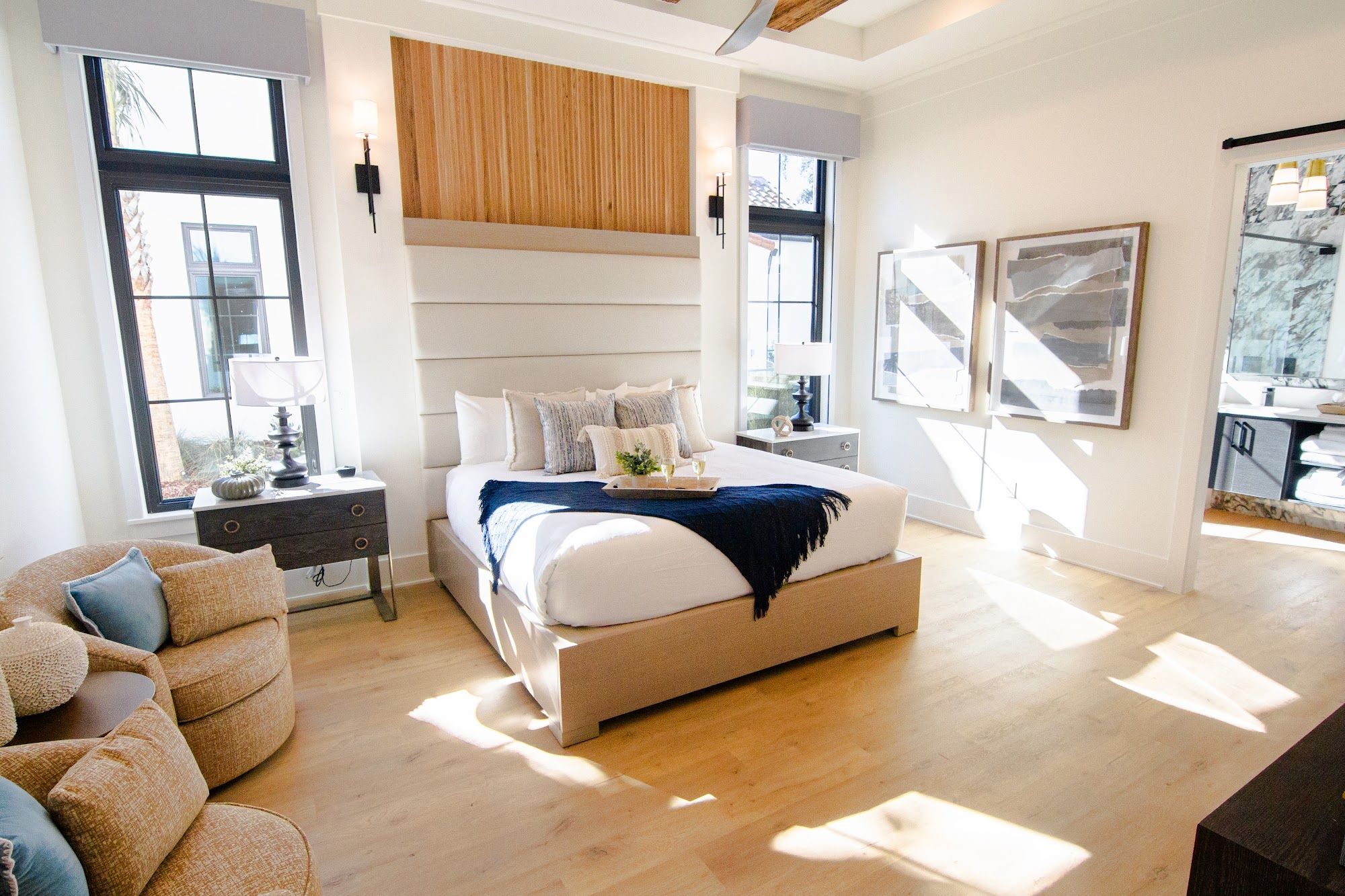 image Bedroom with warm wood tones, large windows, and plush bedding